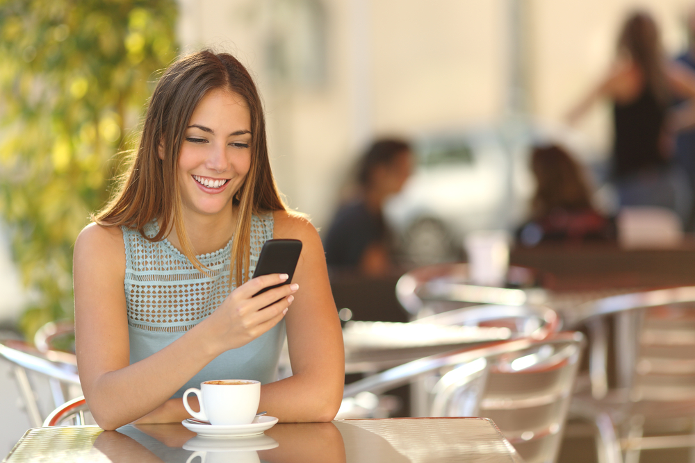 girl-texting-on-the-smart-phone-in-a-restaurant