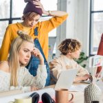 concentrated-female-and-male-casual-businesspeople-working-on-startup-project-with-laptop-in-loft-office